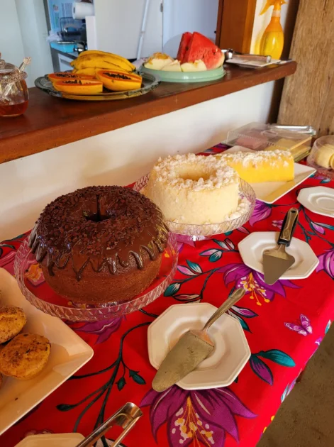 Café da manhã com bolos caseiros e frutas frescas na pousada em Itaúnas